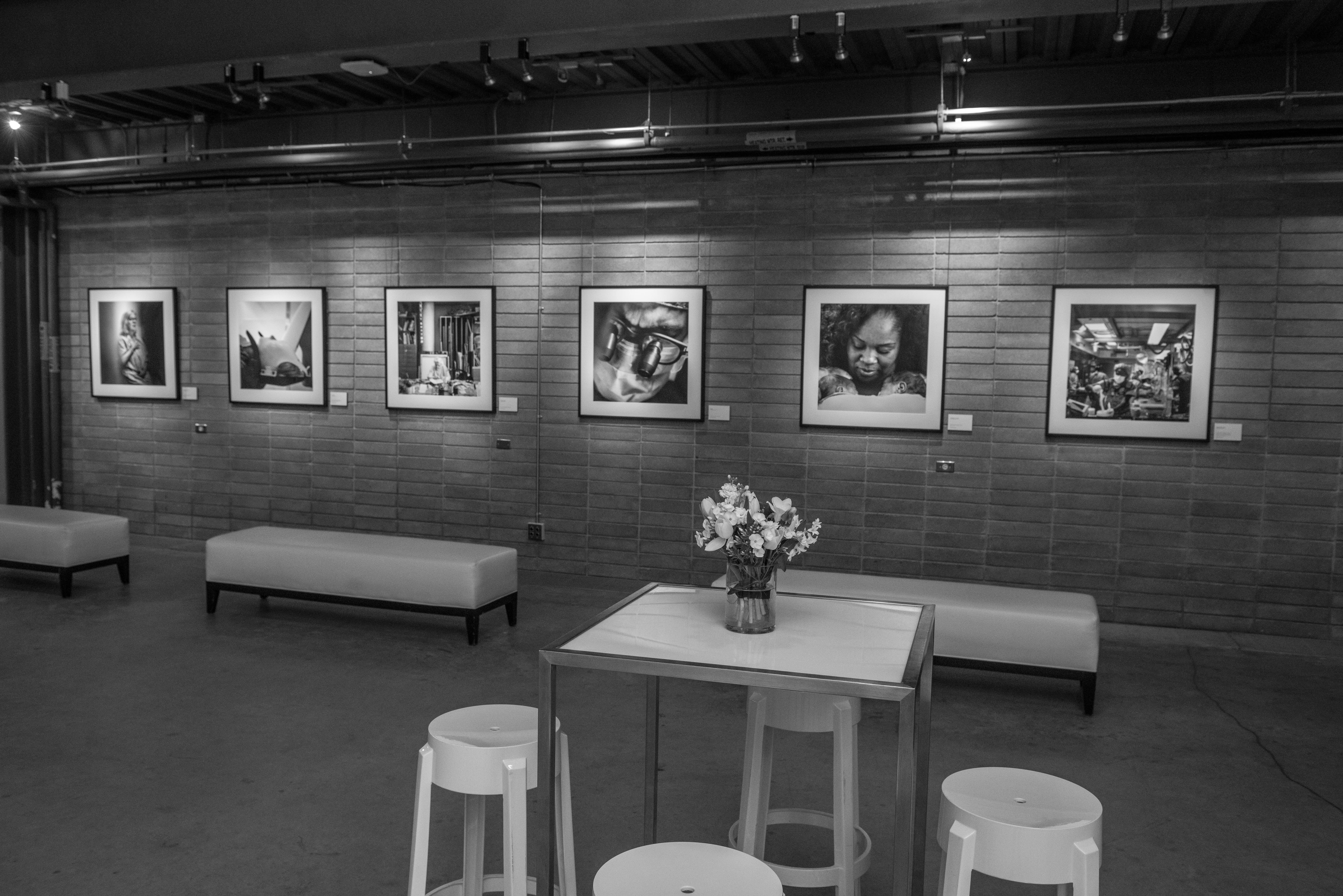 Images from this campaign framed and hung on a brick wall.